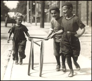 Boys in knickerbockers rolling hoops